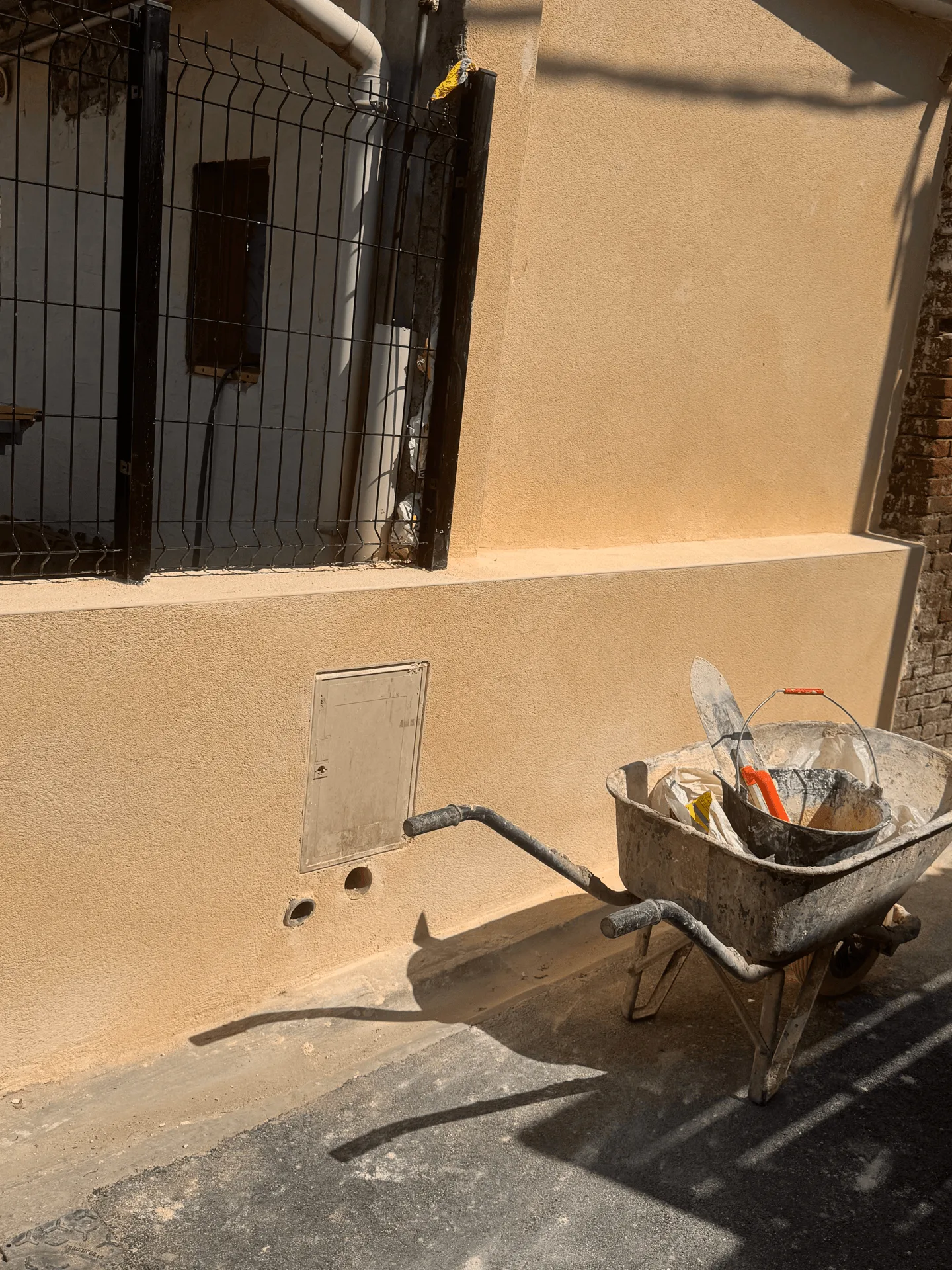 Enduit appliqué sur le mur et le muret, brouette encore présente