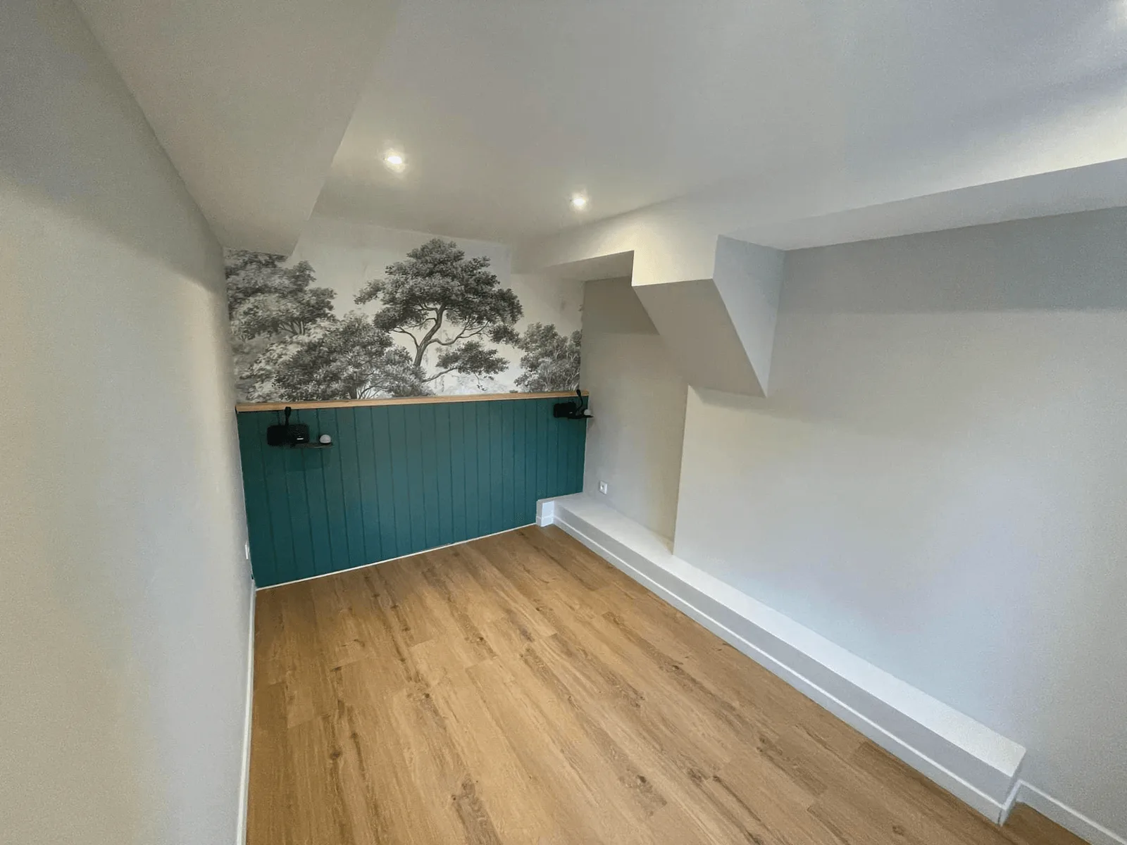 Pièce avec soubassement peint bleu-vert et papier peint à motif végétal